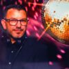 Mario Manni im Porträt neben einer Disco-Kugel
