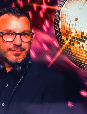 Mario Manni im Porträt neben einer Disco-Kugel